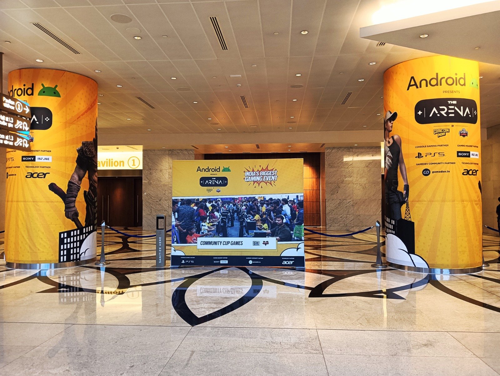Pillar Wrap Branding — Curved fabric pillar wraps and matching media wall across a venue lobby.